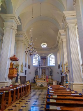 Glubokoe, Belarus, 1 Mayıs 2025. Beyaz neoklasik kilise iç mimarisi. Kuzey Belarus Katolik katedralinde ahşap sıralar ve yüksek tavan. Yüksek kalite fotoğraf.