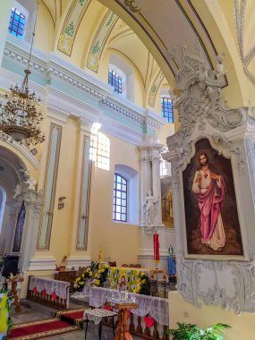 Novorudok, Belarus, May 01, 2025. Grand baroque Catholic church interior showcasing ornate altar colorful religious paintings and magnificent vaulted ceiling with classical architectural elements. High quality photograph