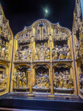 Warsaw, Poland, May 01, 2025. Monumental Gothic carved wooden altarpiece with elaborate multi-tiered biblical scenes exhibited at National Museum showcasing exceptional medieval religious artistry. High quality photograph