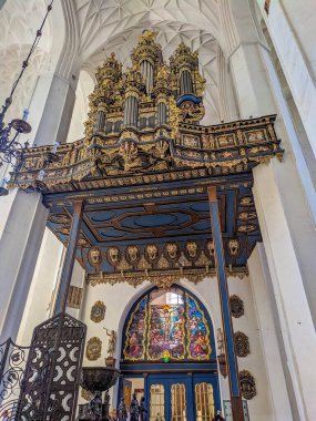 Gdansk, Poland, May 01, 2025. Ornate baroque organ with golden decorations and religious paintings inside St. Mary's Church showcasing intricate musical instrument craftsmanship in Gdansk. High quality photograph
