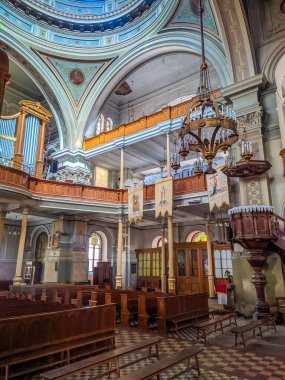 Lodz, Poland, May 01, 2025. Ornate baroque church interior with golden altar detailed ceiling paintings wooden pews and religious decorations in Lodz cathedral sanctuary. High quality photograph