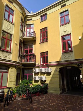 Lodz, Poland, May 01, 2025. Colorful historic buildings with yellow and pink facades along pedestrian street in Lodz old town district during daytime. High quality photograph