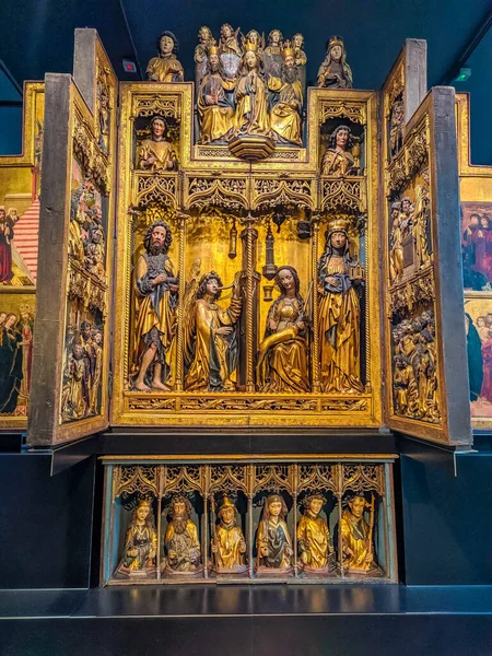 Warsaw, Poland, May 01, 2025. Magnificent Gothic carved wooden triptych altar with elaborate golden relief scenes exhibited at National Museum demonstrating medieval religious artistry. High quality photograph