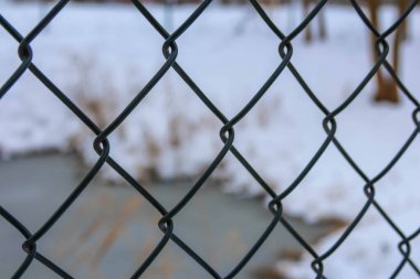 Varşova, Polonya, Ocak 01, 2025. Karla kaplı elmas desenli zincirli çit geometrik kış dokusu arkaplanı oluşturuyor. Yüksek kalite fotoğraf