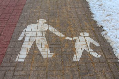 Varşova, Polonya, Ocak 01, 2025. Beyaz, kırmızı tuğlalı yolda yetişkin ve çocukların olduğu yaya ailelerinin kesiştiği semboller çizmiş. Yüksek kalite fotoğraf.