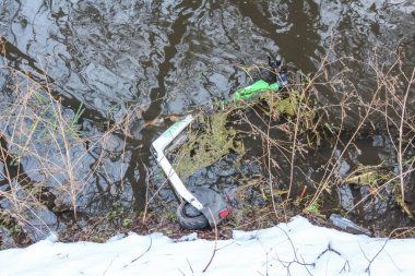 Varşova, Polonya, Ocak 01, 2025. Kışlık park ortamında kurumuş bitki örtüsü ve karın arasında duran yeşil plastik bir şişe kumu. Yüksek kalite fotoğraf
