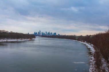 Varşova, Polonya, Ocak 01, 2025. Vistula Nehri kıyısı manzaralı Varşova şehir merkezinin ufuk çizgisi kış akşamında görülebilir. Yüksek kalite fotoğraf