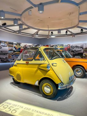 Varşova, Polonya, Mayıs 01, 2025. Klasik sarı Isetta mikro arabası açık hava park alanında diğer antika araçlarla birlikte klasik otomobil sergisinde sergileniyor. Yüksek kalite fotoğraf