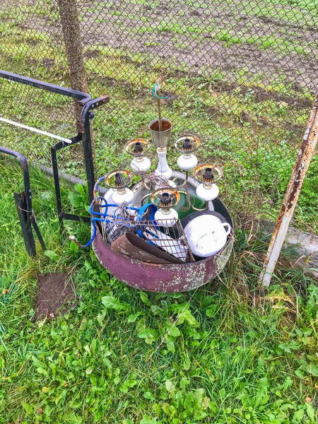 Warsaw, Poland, May 01, 2025. Whimsical garden sculpture featuring mushroom decorations with playful figures nestled among lush green vegetation and climbing vines. High quality photograph