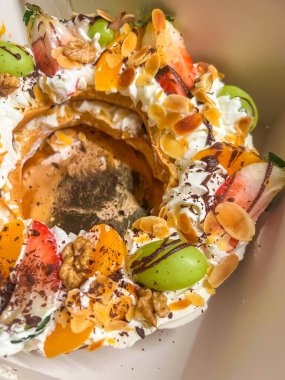 Varşova, Polonya, Mayıs 01, 2025. Varşova 'da beyaz bir tabakta servis edilen hamur kremalı ve taze üzümlü gurme tatlısı. Yüksek kalite fotoğraf.