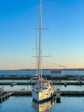 Varşova, Polonya, Mayıs 01, 2025. Sakin bir günde Gdynia limanının sakin sularına tek bir yat direği yansıdı. Yüksek kalite fotoğraf.