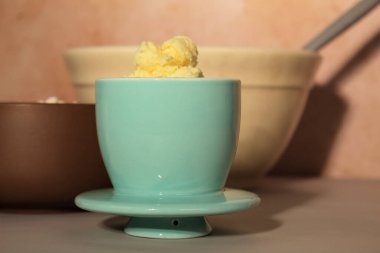 Tereyağlı turkuaz bir tereyağı tabağı. Tereyağı tabağı diğer kaselerin önünde..