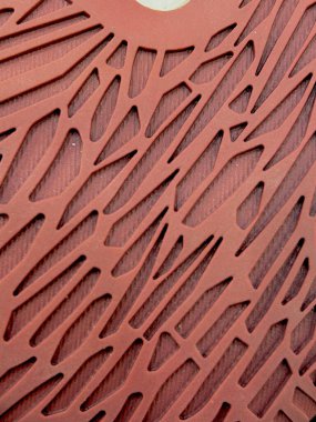 Geometrik kesiklerle kırmızı desenli bir yüzeye yakın plan, soyut, ağ benzeri bir tasarım oluşturur..