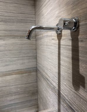 Duvara bağlı eski bir metal, paslı bir musluk..