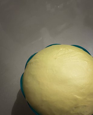 Pürüzsüz, elastik ekmek hamurunun yakın plan görüntüsü. Yeni hazırlanmış ve bir kaseye konmuş..