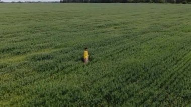 Hava fotoğrafçılığı. Sakallı bir adam yeşil bir tarlanın ortasında dans ediyor..