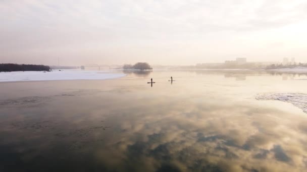 Due persone su un kayak galleggiano su un fiume invernale sullo sfondo di un tramonto — Video Stock