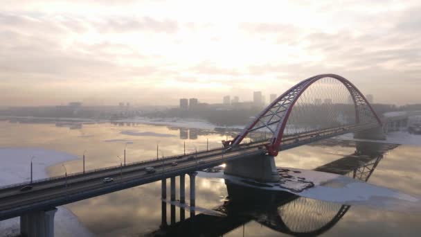 Grand pont sur le fond du coucher du soleil se reflète dans la rivière. Les voitures traversent le pont dans les deux sens — Video