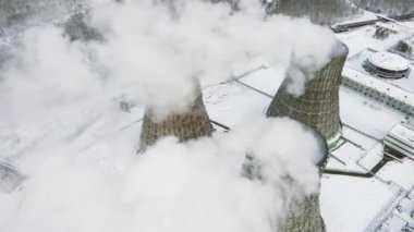 Enerji santrali tarafından yayılan buhar bulutlarının üzerinde uçuyorlar. Üç kule atmosfere karbondioksit yayıyor.