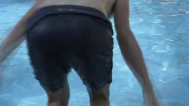 Chlapec skákání do bazénu — Stock video