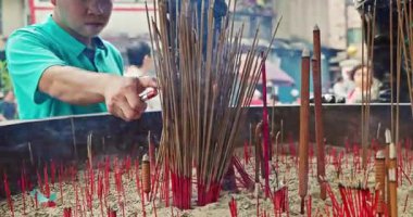 Tapınağın içinde yoğun tütsü çubukları ve kıvrımlı duman tütsüsü yakanlar, dindar dindarları ve yerel halk geleneklerine bir vasiyet olan gelişen tütsü sunucularını sergiliyor..