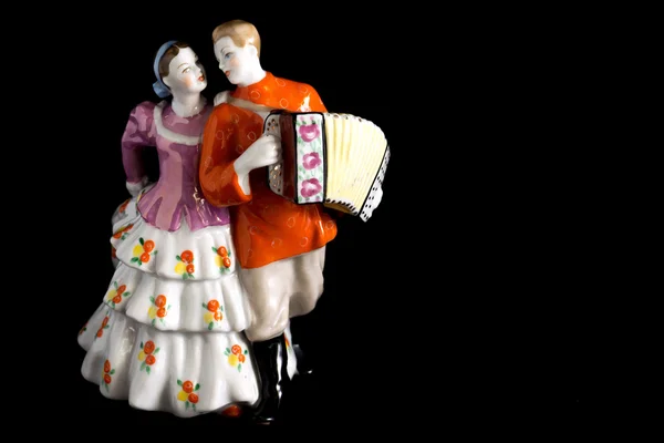 Young couple walking. Porcelain figurine on a black background — Stock Photo, Image