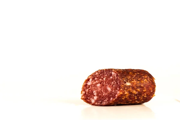 Un morceau de saucisse fumée sur fond blanc — Photo