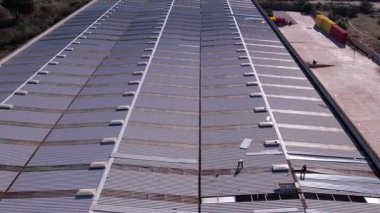 Çatı tamiri. Hasarlı maddeleri kaldırma ve yeni paneller kurma süreci. Ev tadilatı, inşaat, bakım ve çatı tamiratı. İnsansız hava aracı videosu. Napoli, İtalya, 26.10. 2025.