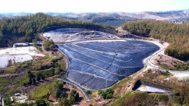 Atık işleme teknolojileri. İnsansız hava aracı gaz toplama sistemini inceliyor. Büyük siyah bir kaplama atık gaz toplama sisteminin önemli bileşenlerini kapsıyor..