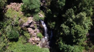 Saklı Şelale 'nin havadan görüntüsü. İnsansız hava aracı videosu yemyeşil dağların derinliklerinde saklı olan şelaleyi yakalıyor..