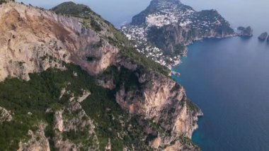 Capri Adası kıyılarının havadan görünüşü. Faraglioni Kayaları. Amalfi Sahili. Turkuaz Tyrhenian Denizi ve İtalya 'nın Capri adasındaki ikonik Faraglioni kaya oluşumlarının çarpıcı insansız hava aracı görüntüleri.