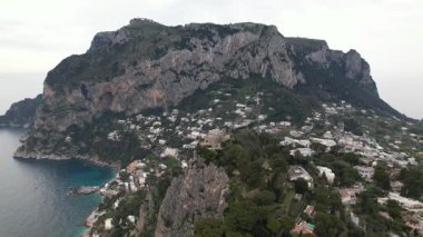 Capri ve Monte Solaro 'nun göz kamaştırıcı manzaraları. Capri 'nin beyaz mimarisinin nefes kesici insansız hava aracı görüntüsü. İtalya 'nın Capri adası Monte Solaro' nun yemyeşil yamaçları ve pırıl pırıl Akdeniz kıyı şeridi