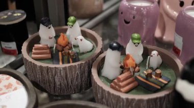 Cadılar Bayramı hayalet şeklinde mumlar bir rafta sergileniyor. Şirin ve ürkütücü bir tatil dekoru..