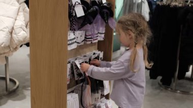 Bebek, perakende satış tezgahında Cadılar Bayramı saç bantları ve aksesuarlarını karıştırıyor. Mevsimlik alışveriş zamanı