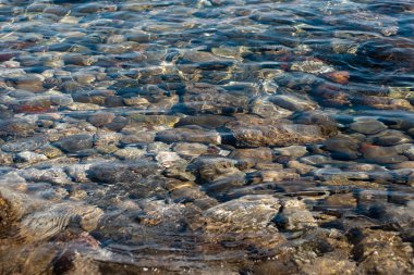 Top down view of calm clear water and rock bottom surface of Gulf of Corinth shoreline