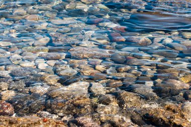 Top down view of calm clear water and rock bottom surface of Gulf of Corinth shoreline