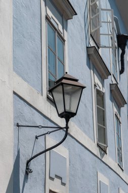 Klasik sokak lambası ve Salzburg, Avusturya 'da açık pencereli geleneksel pastel mavi bina, tarihi Avrupa mimarisini gözler önüne seriyor