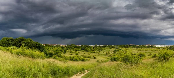 Dramatic view of a shelf cloud over a field, horizontal cloud fo