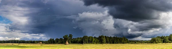 Dramatic view of a shelf cloud over a field, horizontal cloud fo