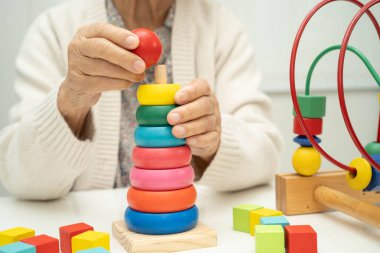 Asyalı yaşlı bir kadın, geliştirme oyunu oynuyor..