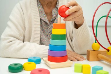 Asyalı yaşlı bir kadın, geliştirme oyunu oynuyor..