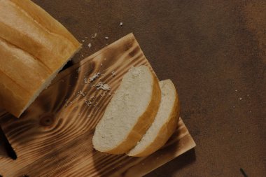 Mutfak tahtasının üzerinde dilimlenmiş bir somun ekmek resmi