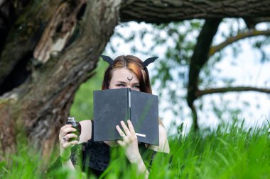 Genç ve güzel büyücü bir yaz günü yeşil bir ormanda bir tören düzenler. Modern cadılık..