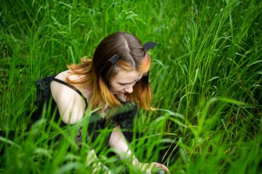 Siyah elbiseli genç ve güzel cadı bir yaz günü yeşil bir ormanda bir tören düzenliyor. Modern cadılık..