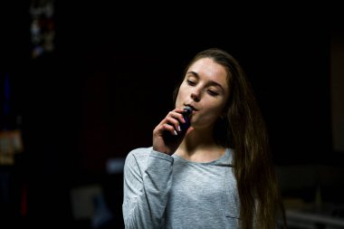 Buharlı genç. İçeride elektronik sigara içen, beyaz tenli, beyaz, genç bir kız. Çok kötü bir alışkanlık. Vestiyer etkinliği.