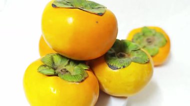 Fresh ripe orange persimmon fruit on white background.