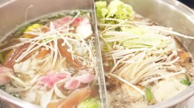 Yosenabe Shabu domuz eti fondüsü, deniz ürünleri ve sebzeler tencereye konur..