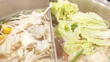 Yosenabe Shabu domuz eti fondüsü, deniz ürünleri ve sebzeler tencereye konur..