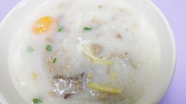 Pirinç lapası veya pirinç çorbası domuz eti yumurta ile dilimlenmiş zencefil ve sebze. Lezzetli kahvaltı.