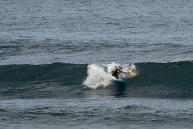 Saint-Jean-de-Luz, P-A / Fransa - 22 Ekim 2020: Atlantik Okyanusunda sörf yapan orta yaşlı bir adam